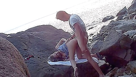 Girl and guy are having sex on the beach in the public park